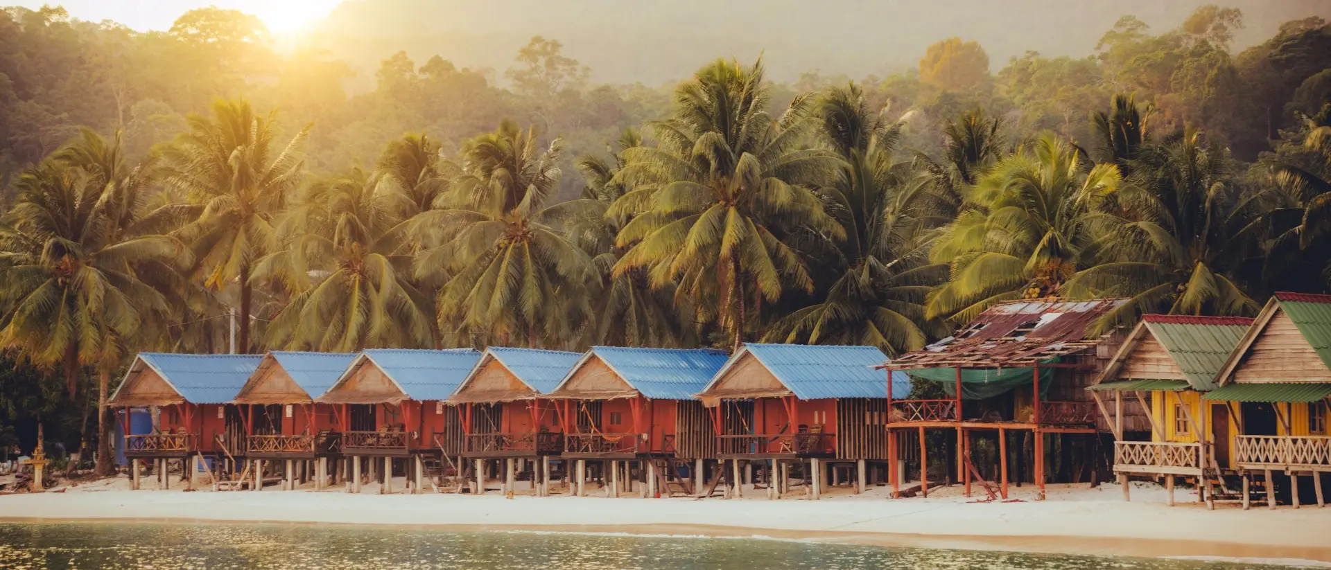 Elevated bungalows along beach with lush palm trees on the secluded Island Koh Rong Sanloem, Sihanoukville Province, Cambodia