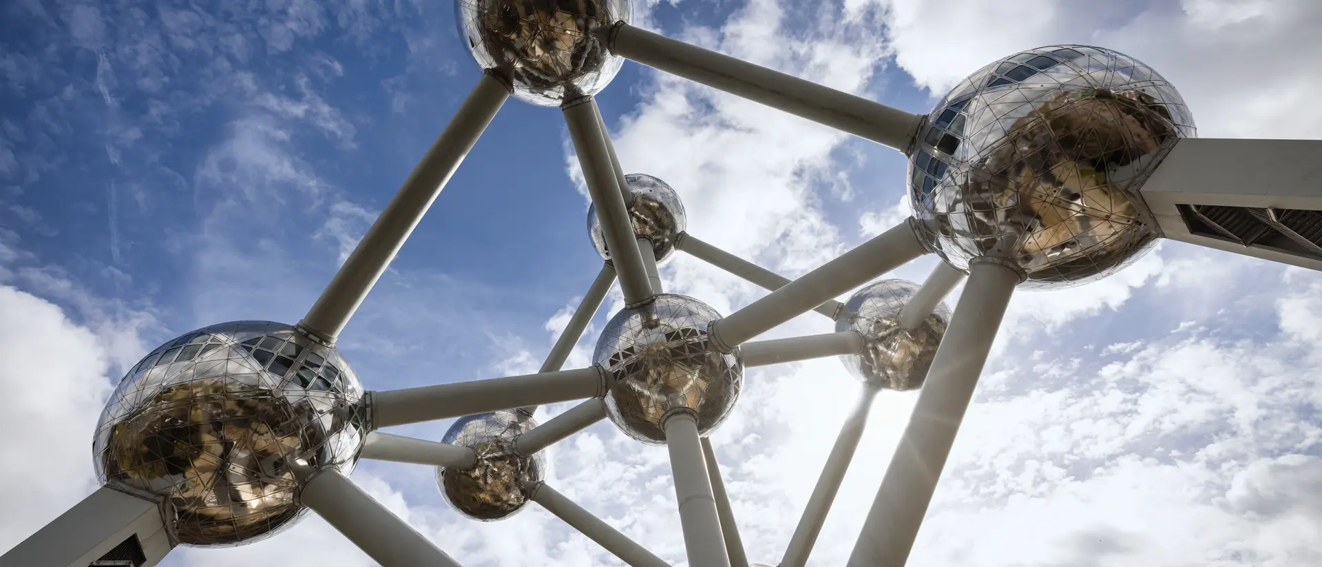 The Brussels Atomium Monument from below under blue summer sky.
