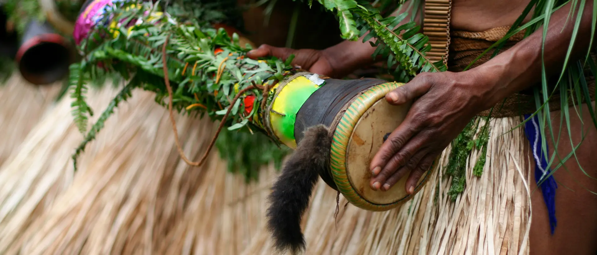 Tribal Ceremony, Papua New Guinea. Woman beating a hand-made drum as part of a tribal ceremony. Papua New Guinea.