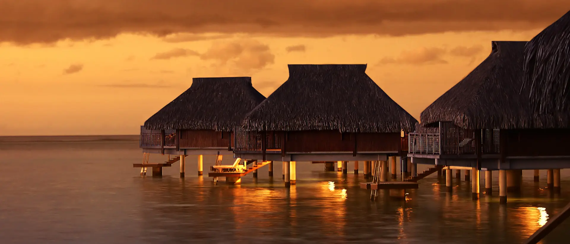 Tropical Tahiti bungalows at sunset