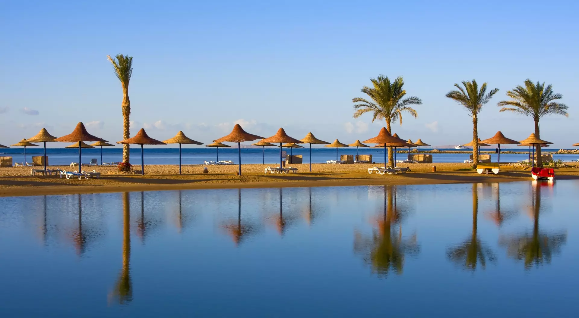 Straw umbrella on the beach, provides a perfect shady retreat amidst golden sands and crystal-clear waters.