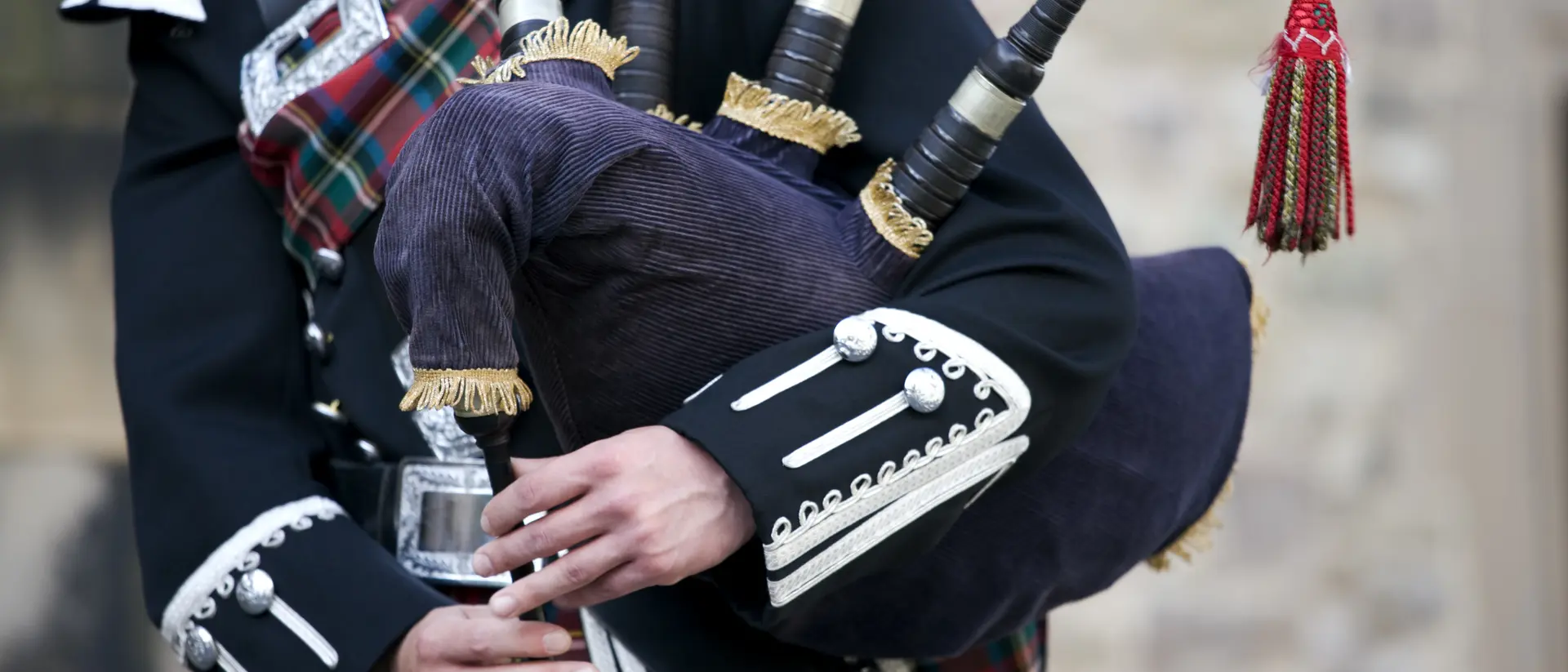 Edinburgh, Scotland Close up of the hands of a Scottish bagpiper clad in a traditional scottish tartan playing the Scottish bagpipe
