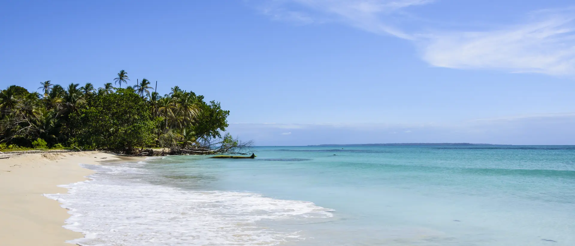 White sand beach on a tropical island surrounded by a turquoise sea.