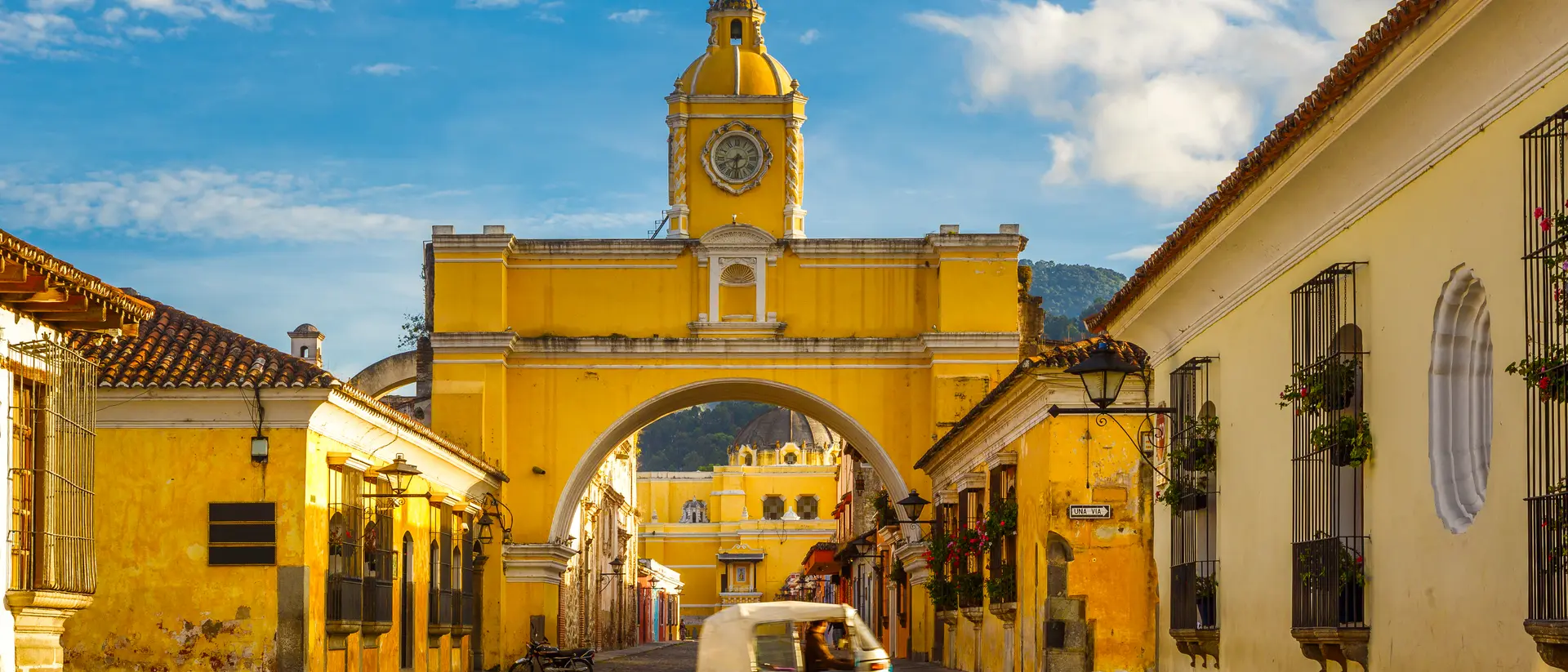 The Arch of Santa Catalina, Antigua A tuk-tuk taxi passes in from of The Arch of Santa Catalina in Antigua, Guatemala