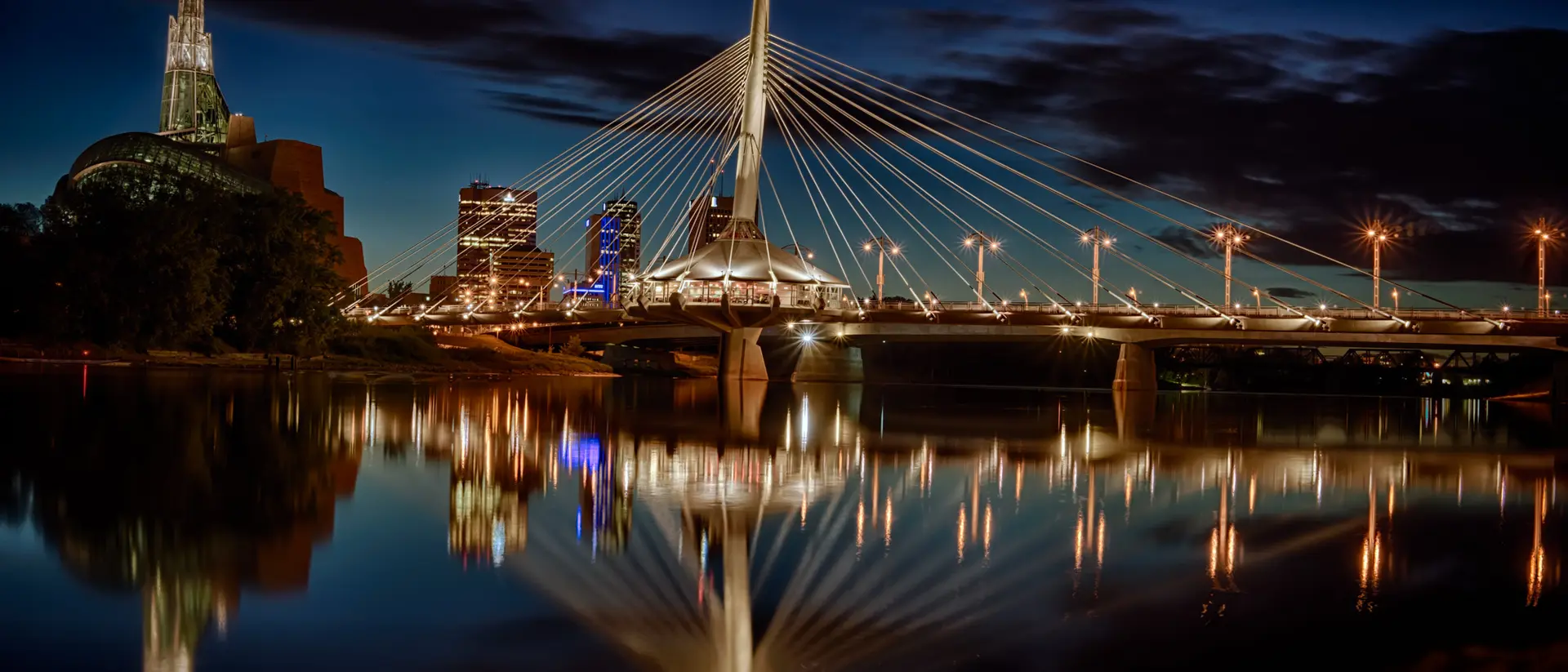 Reflection of the city skyline and the Esplanade Riel Bridge over the Red River at the blue hour
