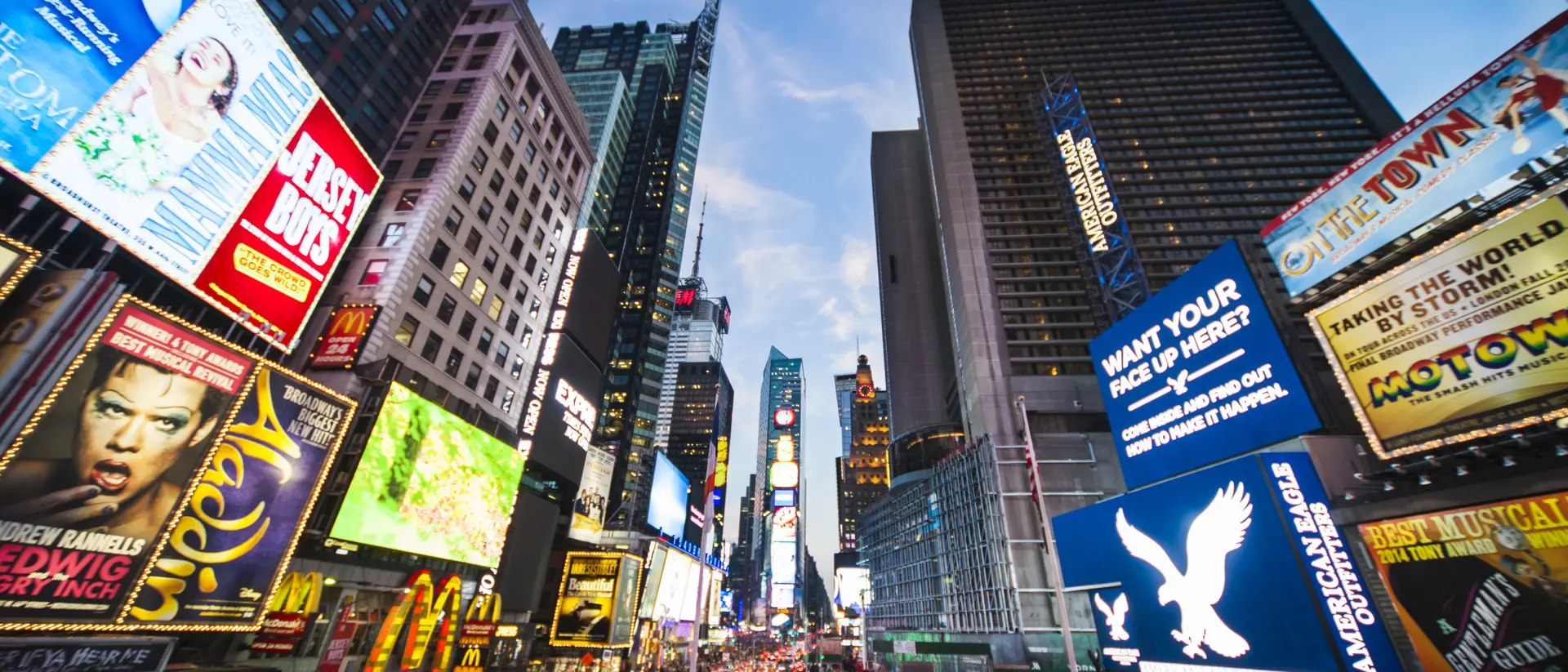 Times Square, New York City, United States Tourists crossing Times Square surrounded by bright lights and advertisements