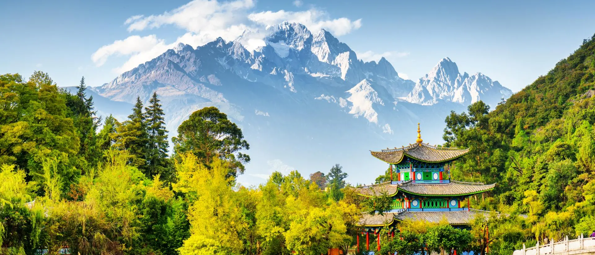 Jade Spring Park Scenic view of the Jade Dragon Snow Mountain and the Moon Embracing Pavilion on the Black Dragon Pool in the Jade Spring Park, Lijiang, Yunnan province, China.