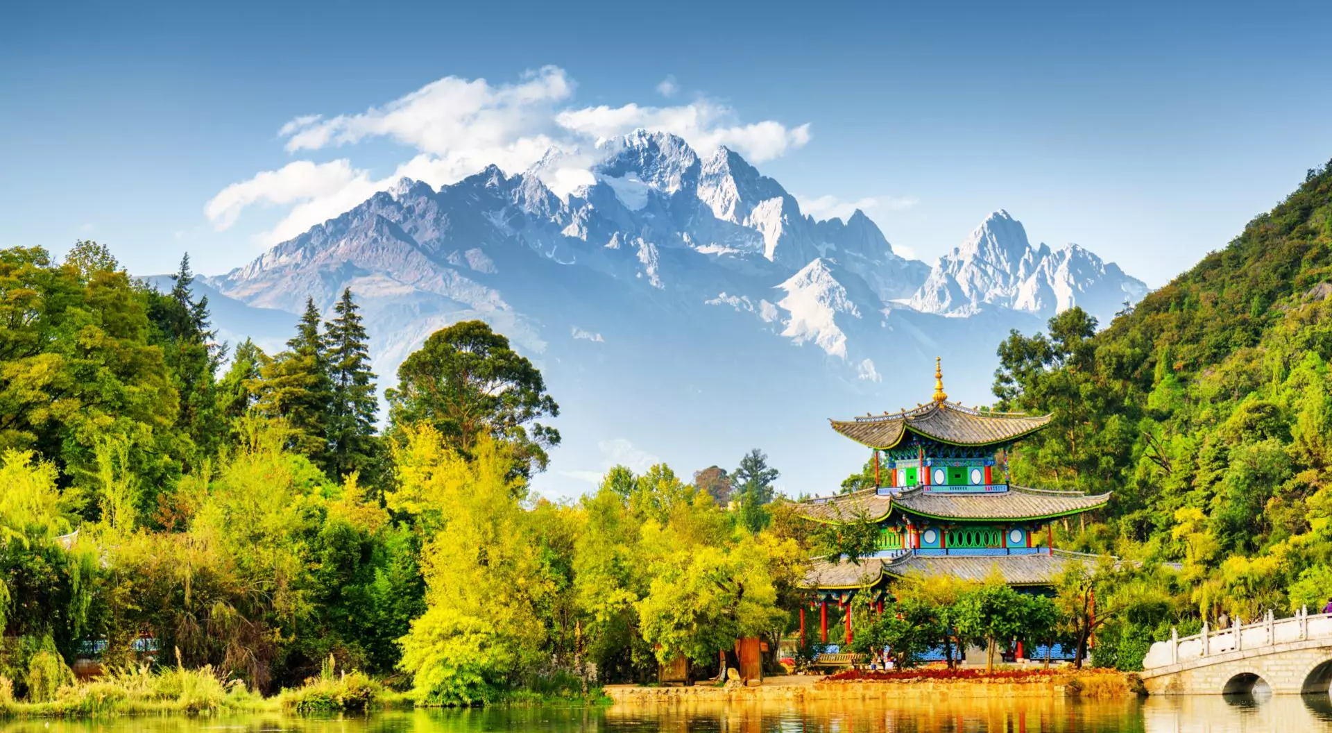 Scenic view of the Jade Dragon Snow Mountain and the Moon Embracing Pavilion on the Black Dragon Pool in the Jade Spring Park, Lijiang, Yunnan province, China.