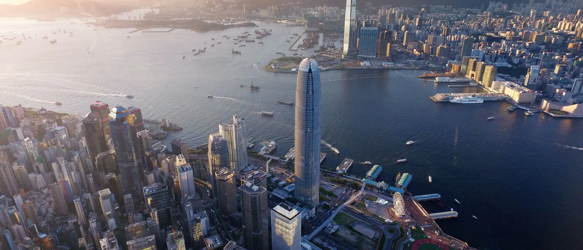 Dramatic skyline of Hong Kong Island and busy ships navigates across the Victoria Harbour during beautiful sunset