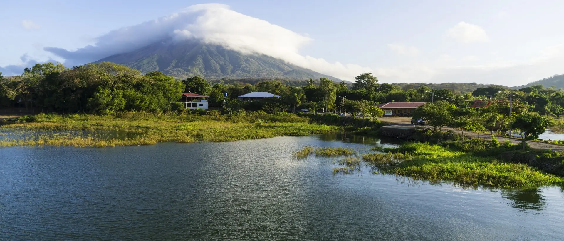 Morning view from Lake Nicaragua to island Ometepe and volcano Concepcion with white clouds on it