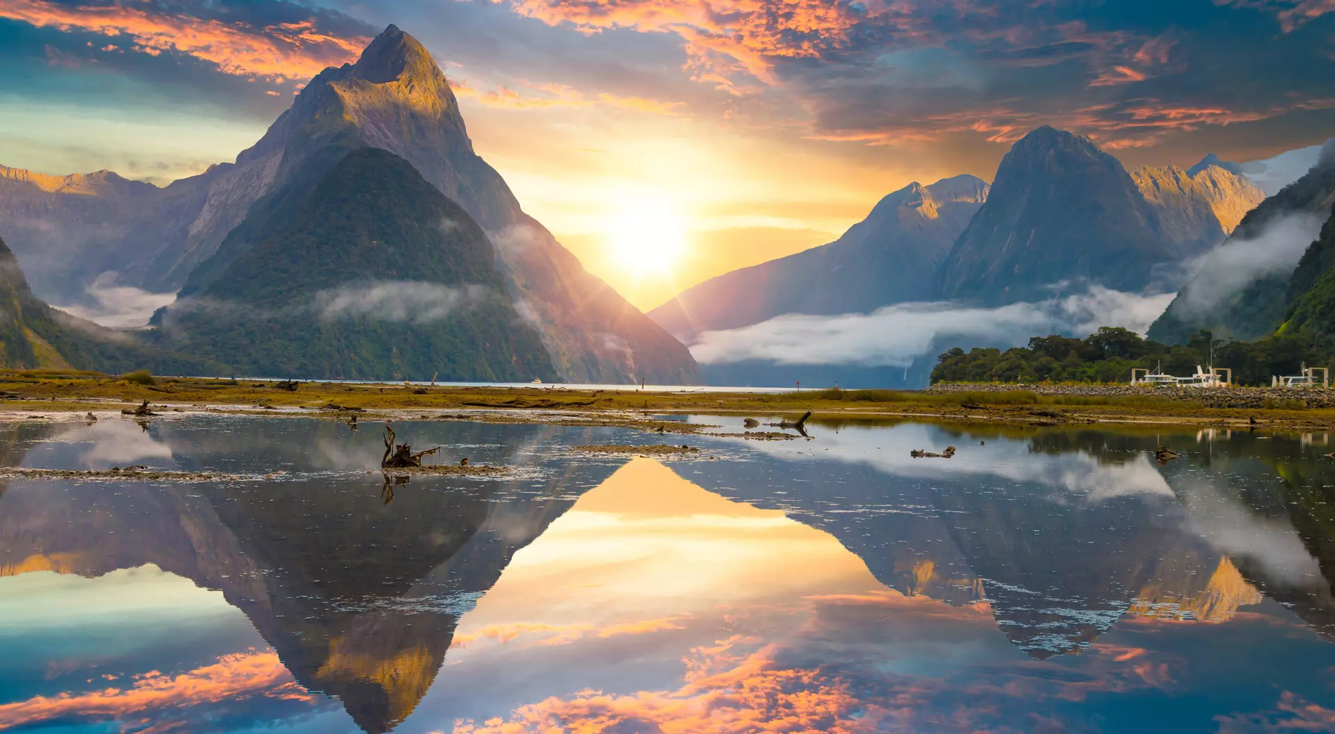 Famous Mitre Peak rising from the Milford Sound fiord with the mountains reflecting in the water