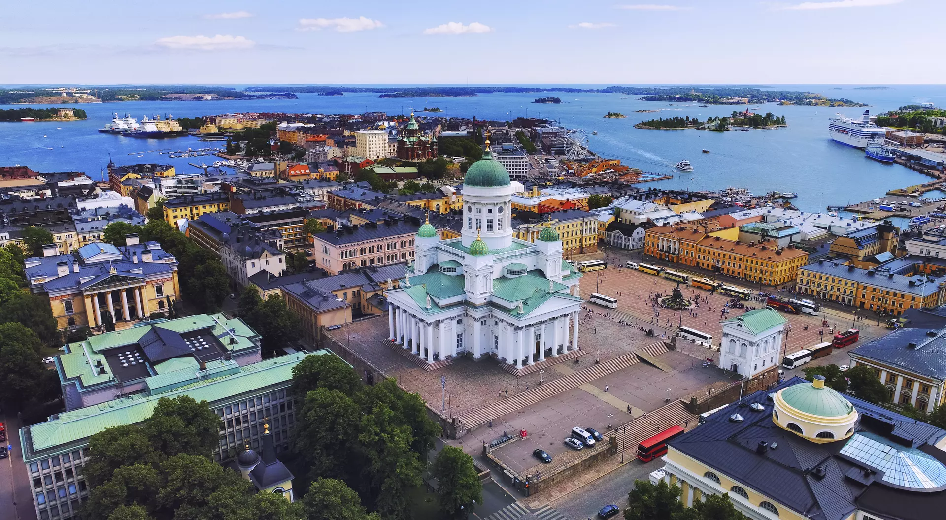 Aerial view of Helsinki, featuring the iconic white cathedral and vibrant waterfront buildings along the harbor.