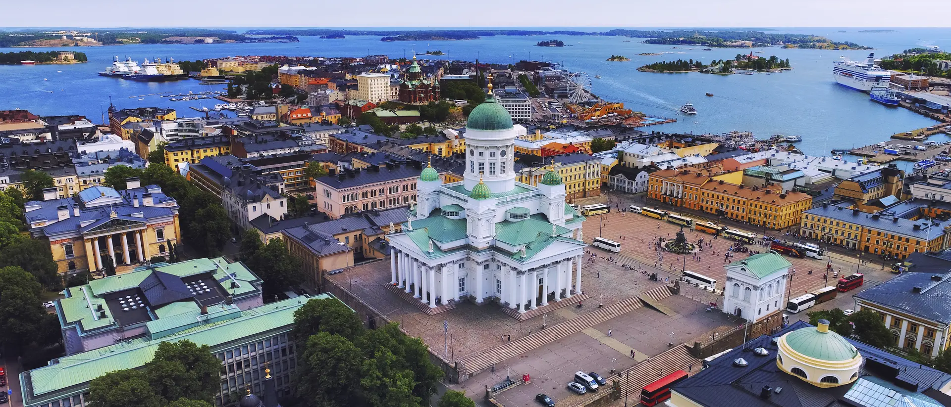 Aerial view of Helsinki, featuring the iconic white cathedral and vibrant waterfront buildings along the harbor.