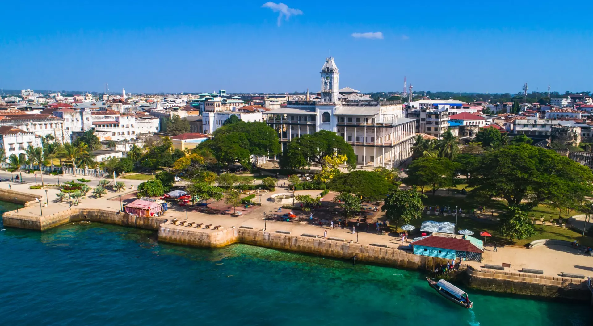 A bird's-eye view of Stone Town, captures the essence of this historic coastal city, its vibrant streets and ancient landmarks intertwined with the azure embrace of the Indian Ocean.