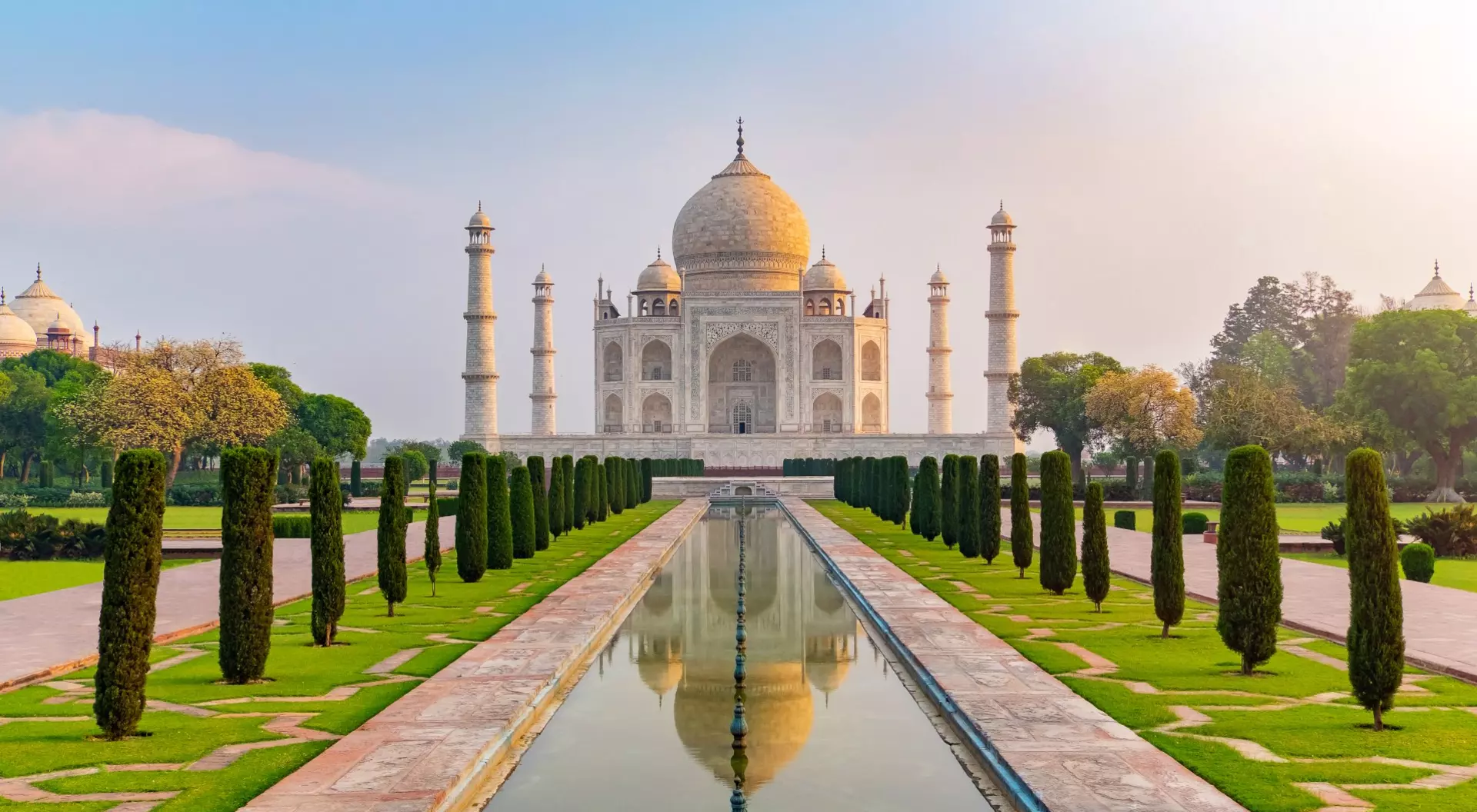 Taj Mahal front view reflected on the reflection pool, an ivory-white marble mausoleum Agra, Uttar Pradesh, India. One of the seven wonders of the world