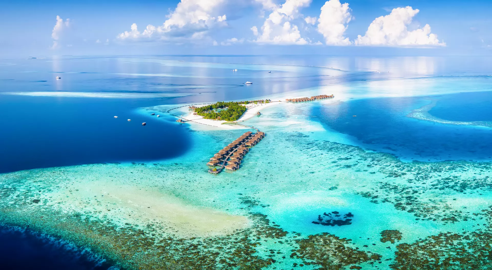 Aerial view of a resort with overwater bungalows in the Maldives.