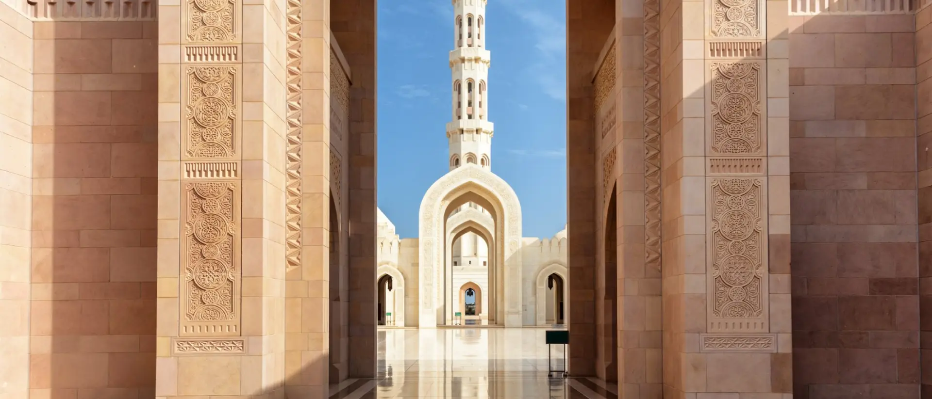 View of minaret through arches of Sultan Qaboos Grand Mosque