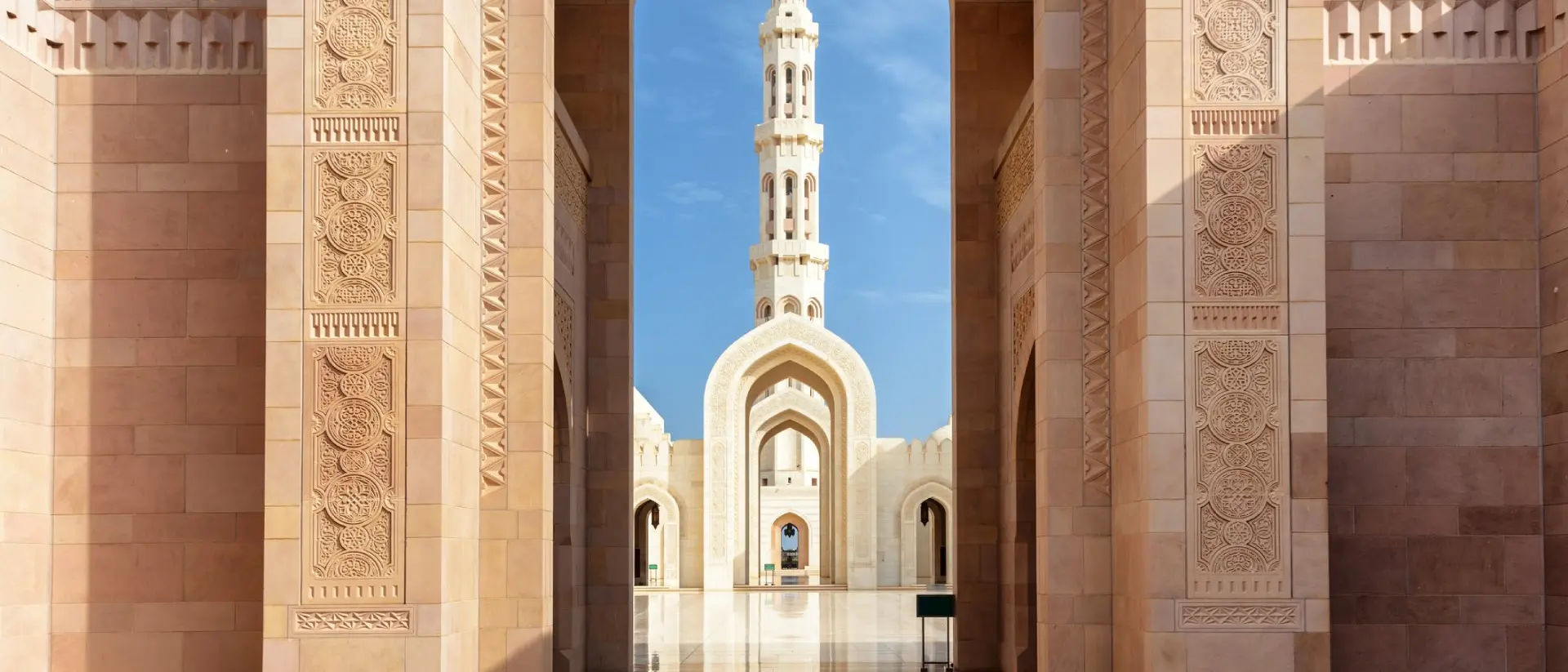 View of minaret through arches of Sultan Qaboos Grand Mosque