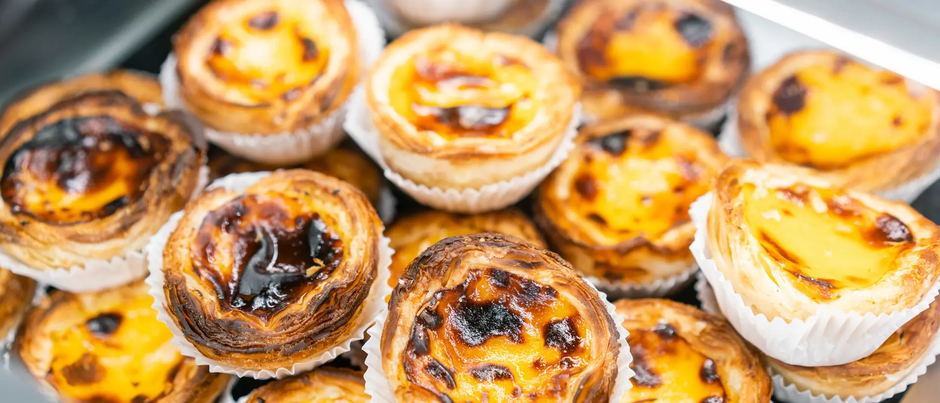 Rows of egg tarts at a bakery in Lisbon, Portugal