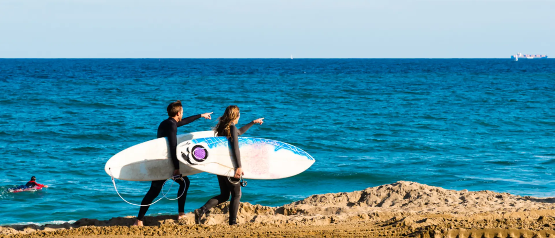 Surfers walking Along the Beach