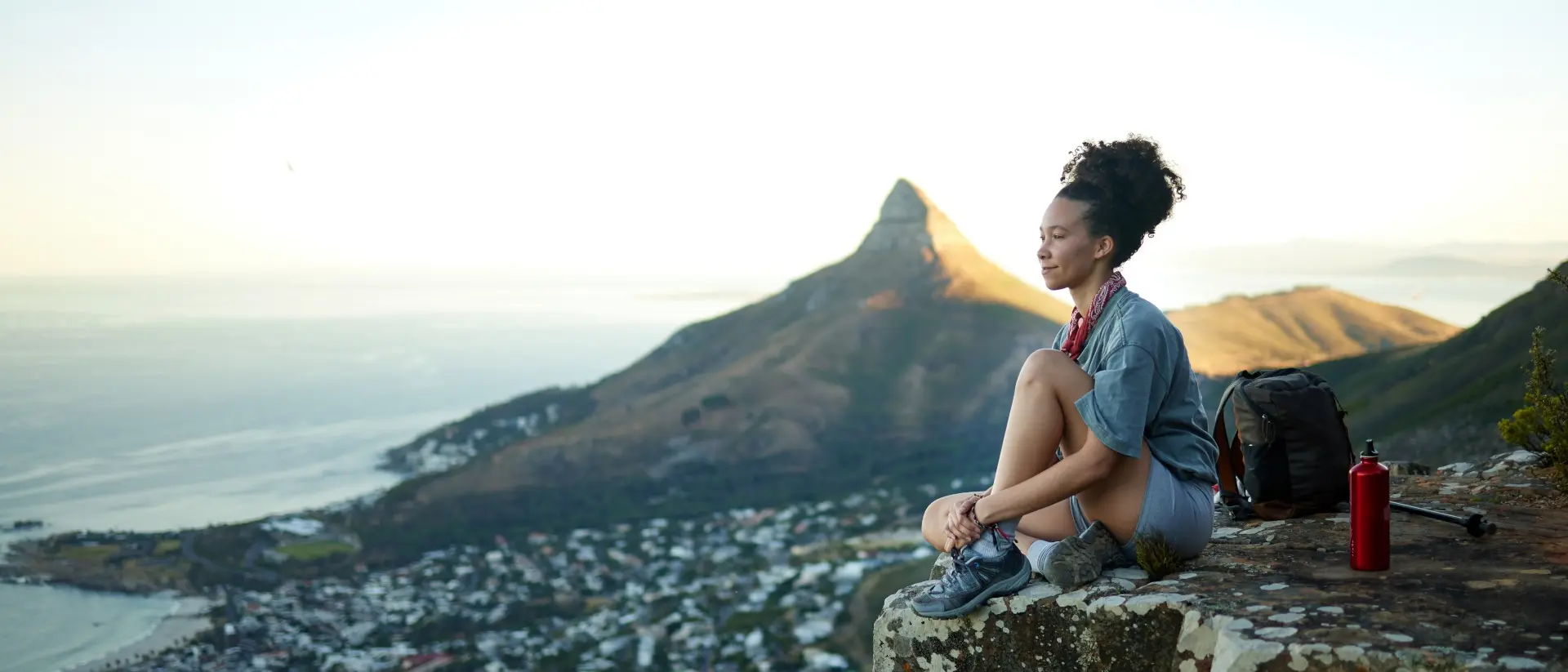 Table Mountain, Cape Town, South Africa woman on the edge of a mountain overlooking city and ocean