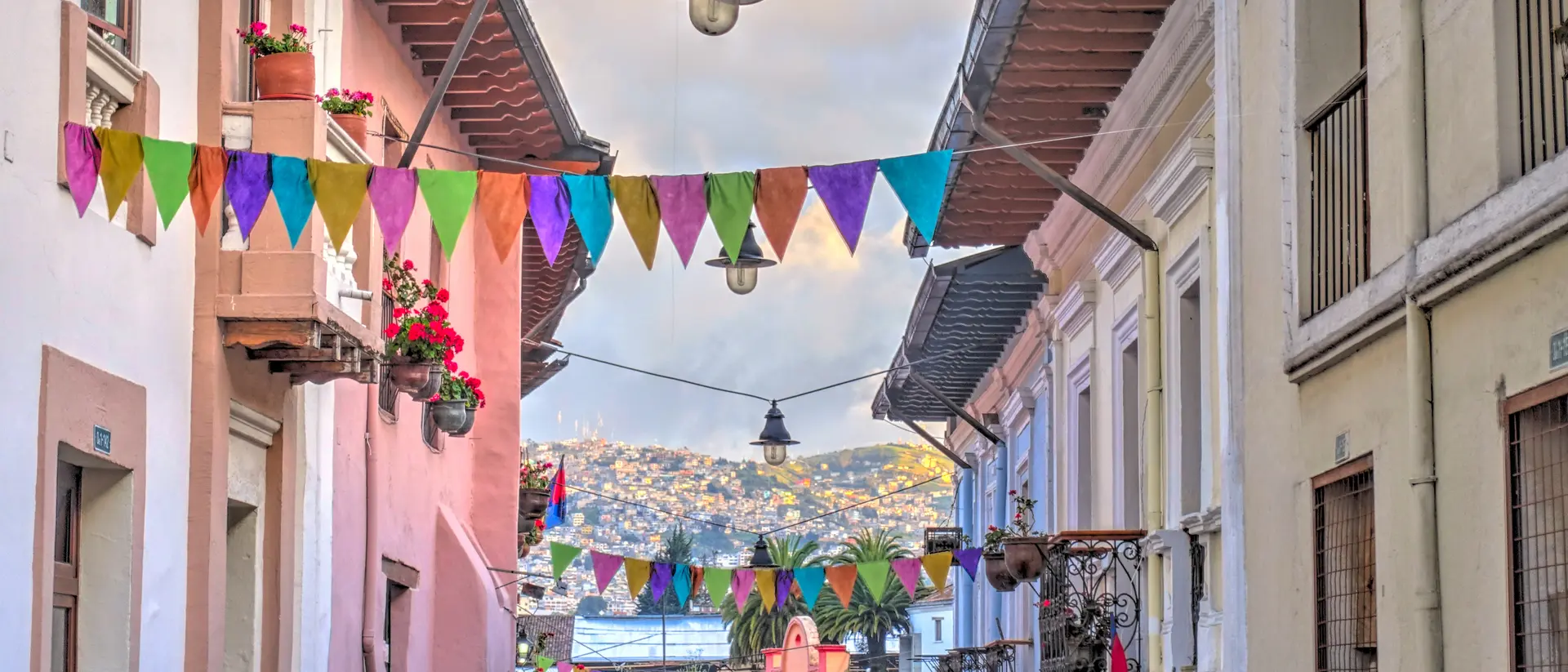 Flags overtop of narrow pedestrian street in Quito