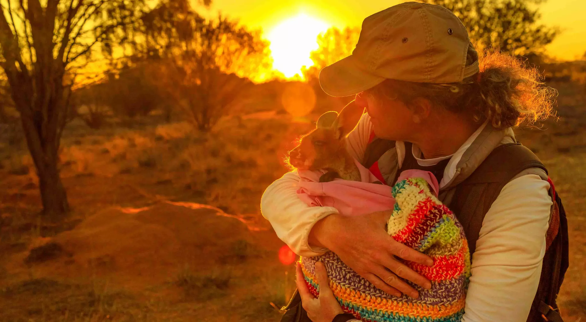 woman holding a baby kangaroo in a blanket