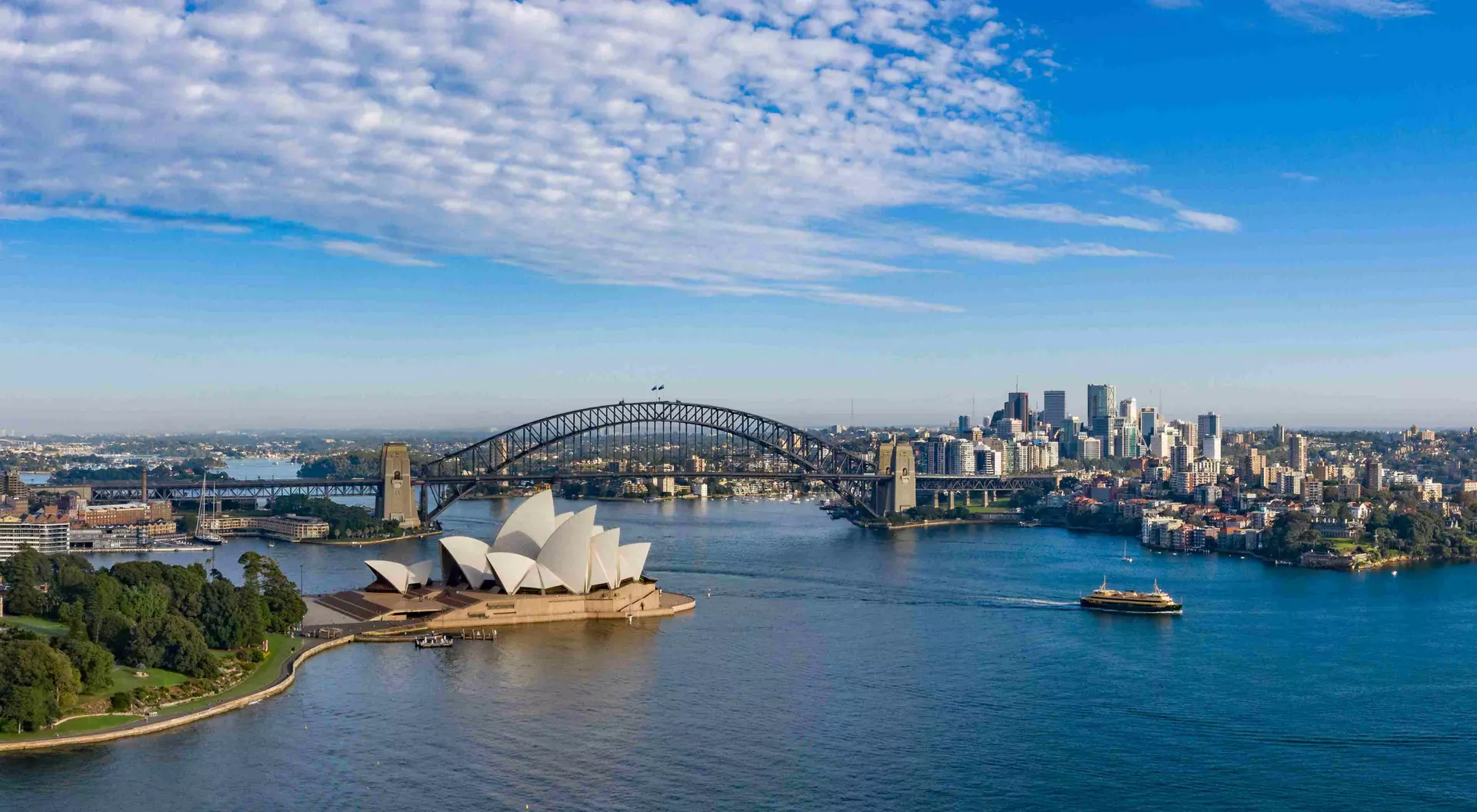 aerial view of a beautiful harbour with opera house, bridge, and ciy