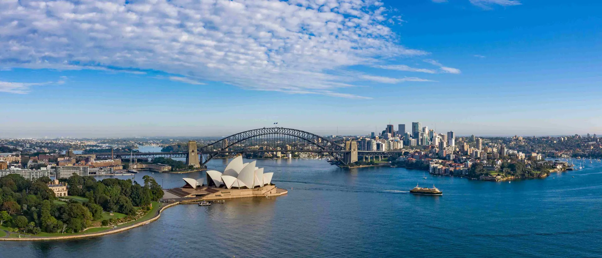 aerial view of a beautiful harbour with opera house, bridge, and ciy