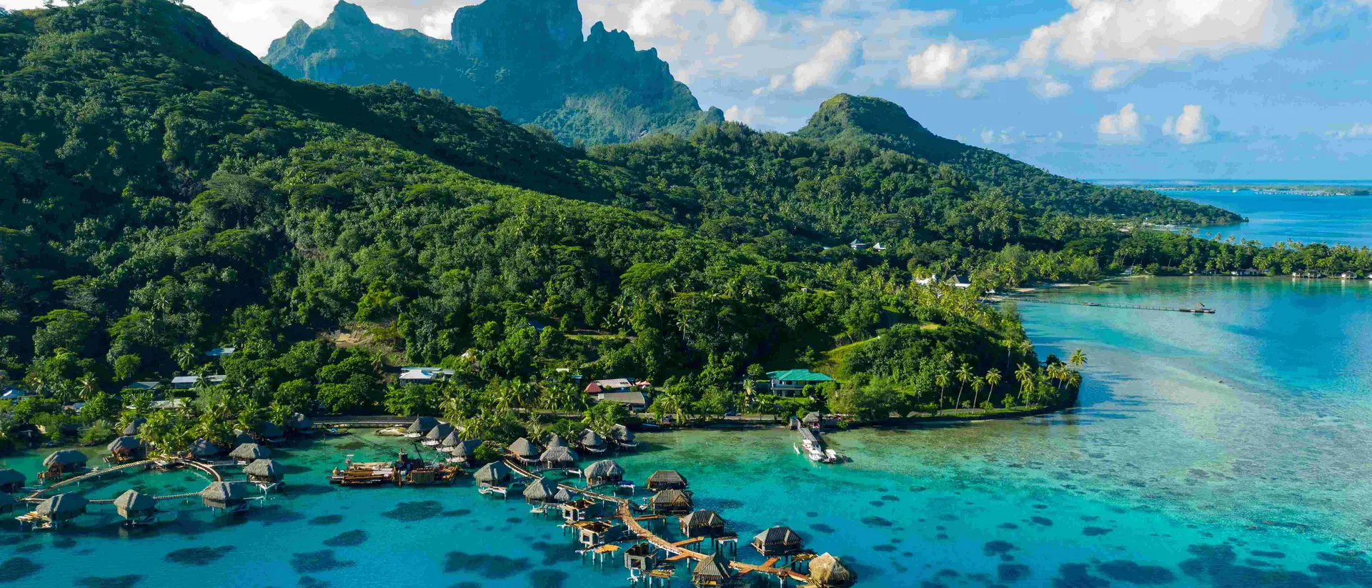 aerial view of resorts and green mountains with blue waters