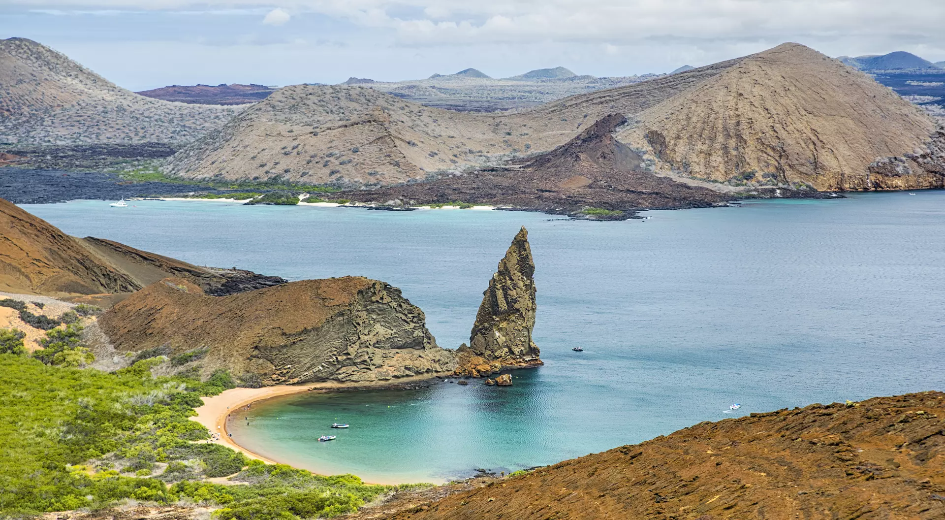 Aerial view of the famous Pinnacle Rock on the small island of Bartolome, Galapagos, Ecuador. In the background is Santiago island.