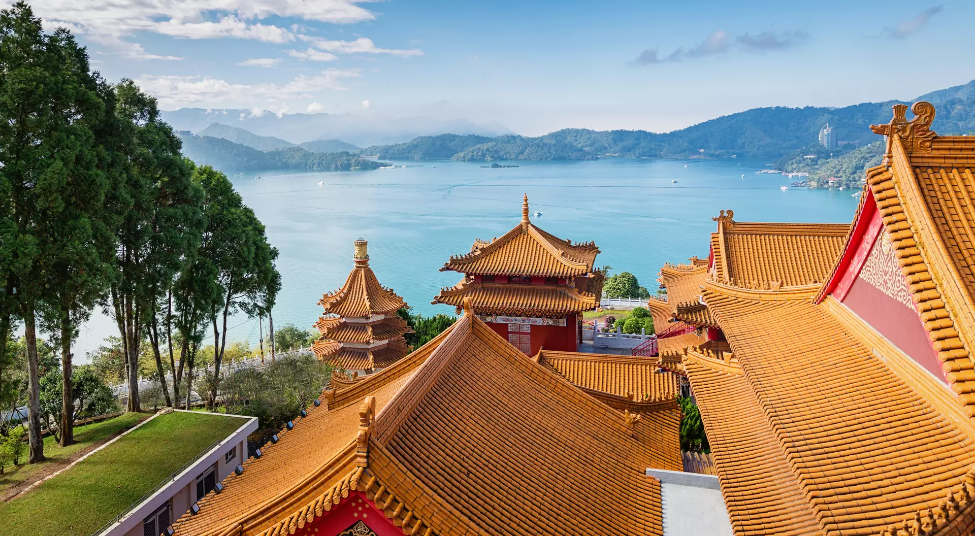 Beautiful view towards the famous Sun Moon Lake View under blue sunny sky over Wen Wu Temple Rooftops. 