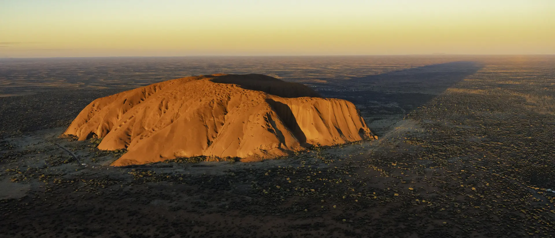 Evening sun shines down on the magnificence of Uluru