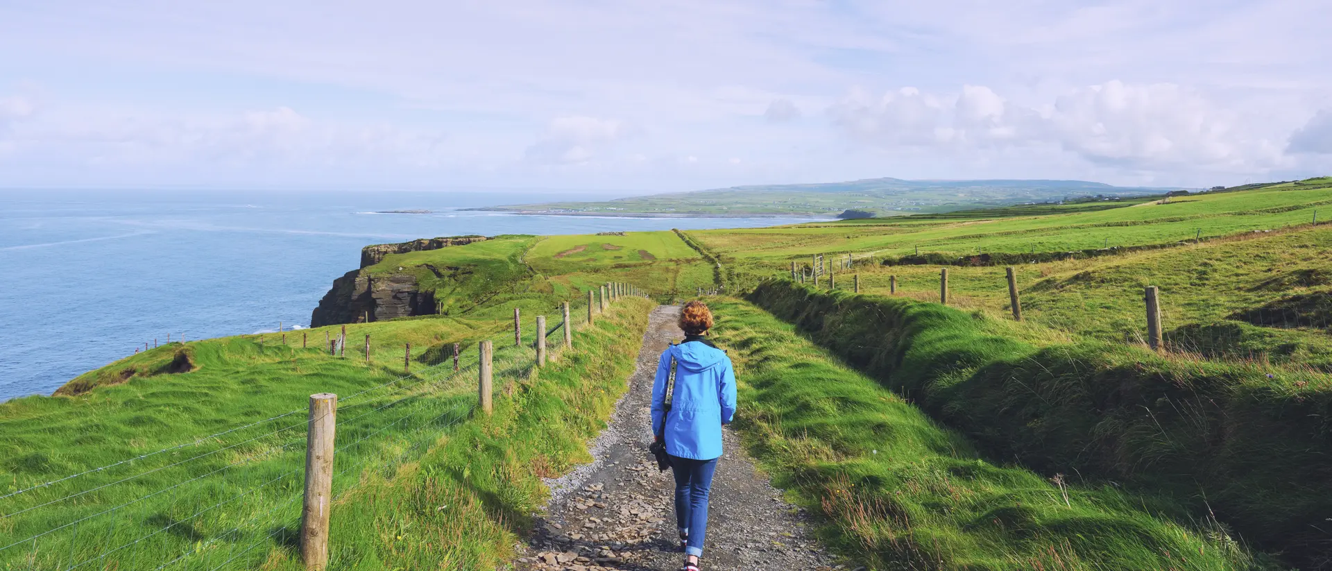 Woman trekking on Cliffs of Moher walking trail in Ireland