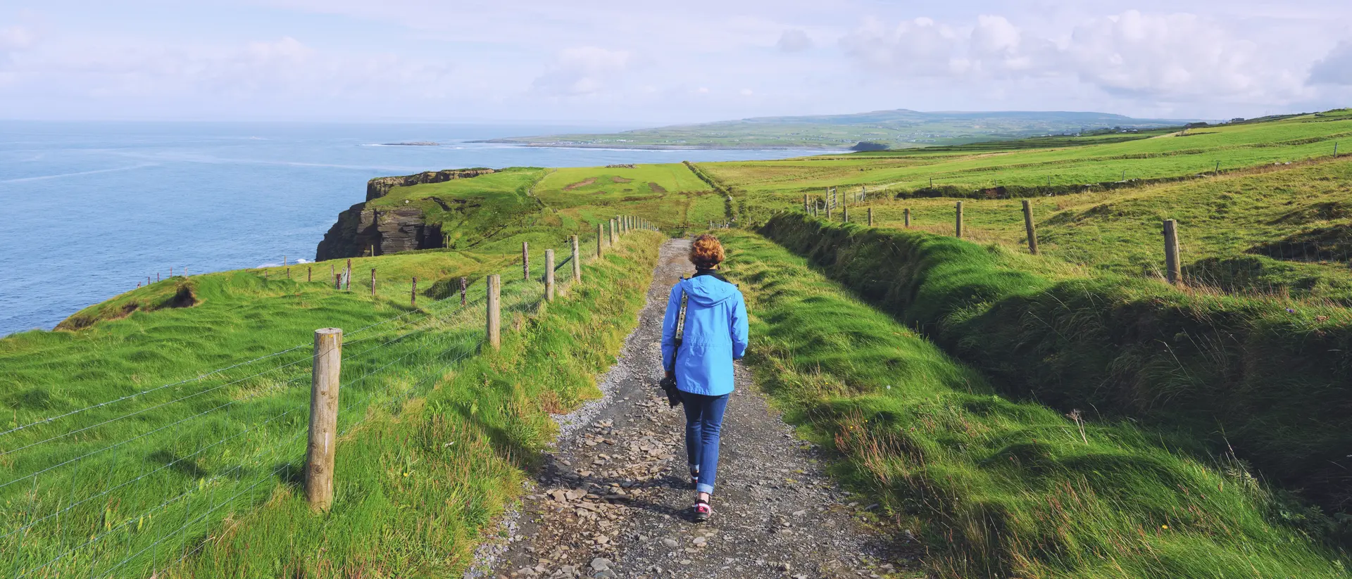 Woman trekking on Cliffs of Moher walking trail in Ireland