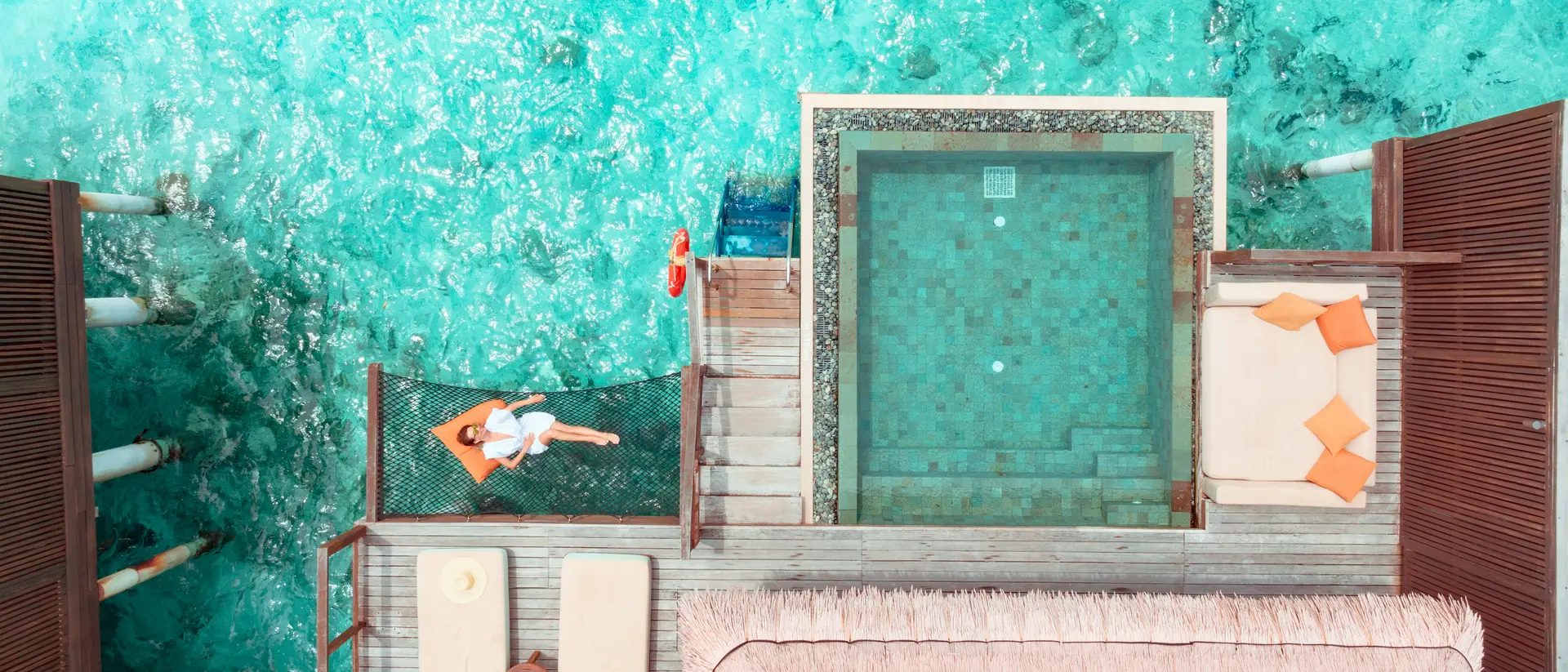 Woman lying on hammock over ocean.