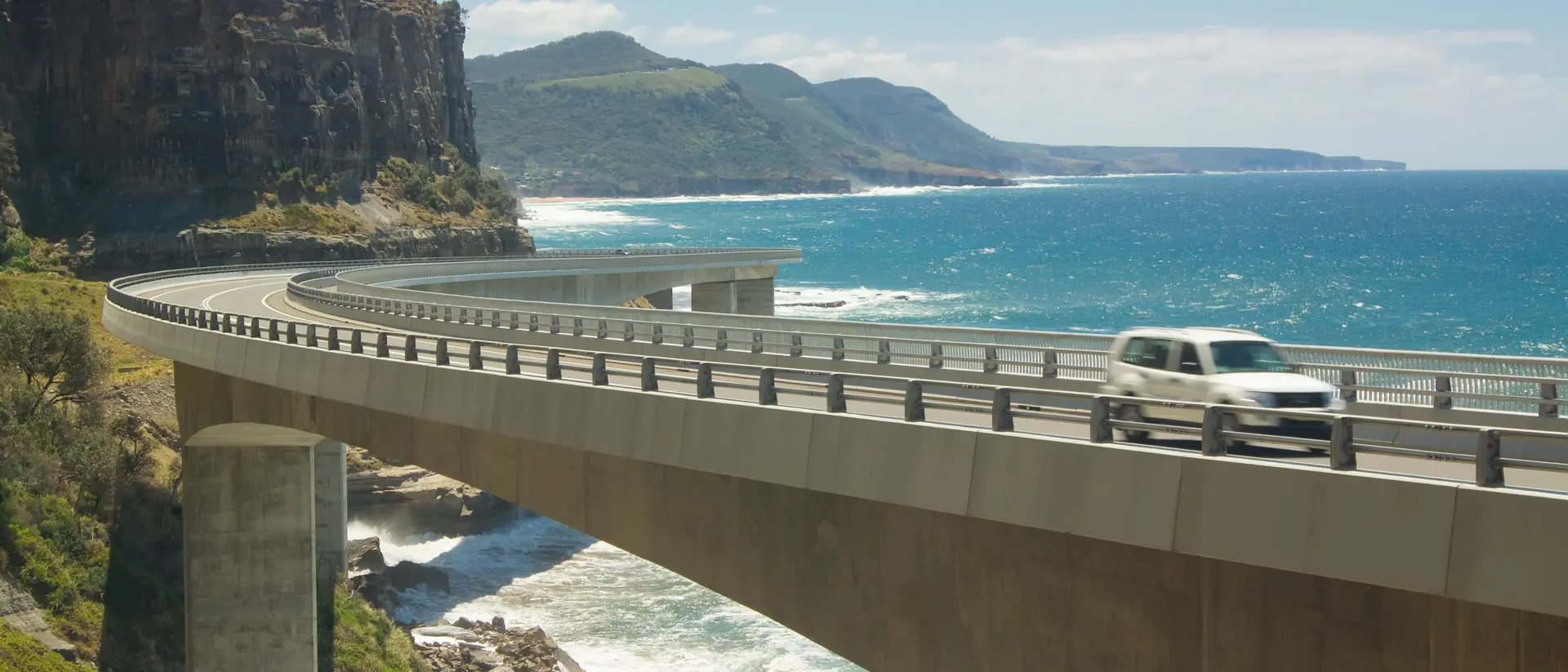 A car goes across the Sea Cliff Bridge