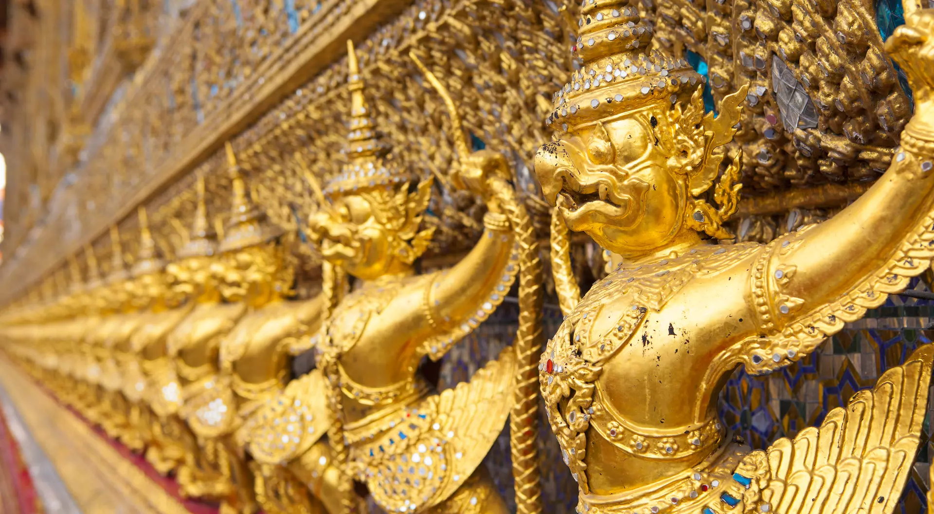 The Ubosot (Ordination Hall) at Wat Phra Kaew temple, Grand Palace, Bangkok. It is decorated with a golden row of 112 Garudas (demigods).