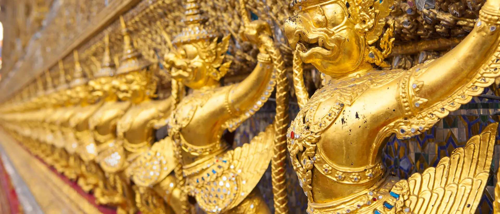 The Ubosot (Ordination Hall) at Wat Phra Kaew temple, Grand Palace, Bangkok. It is decorated with a golden row of 112 Garudas (demigods).