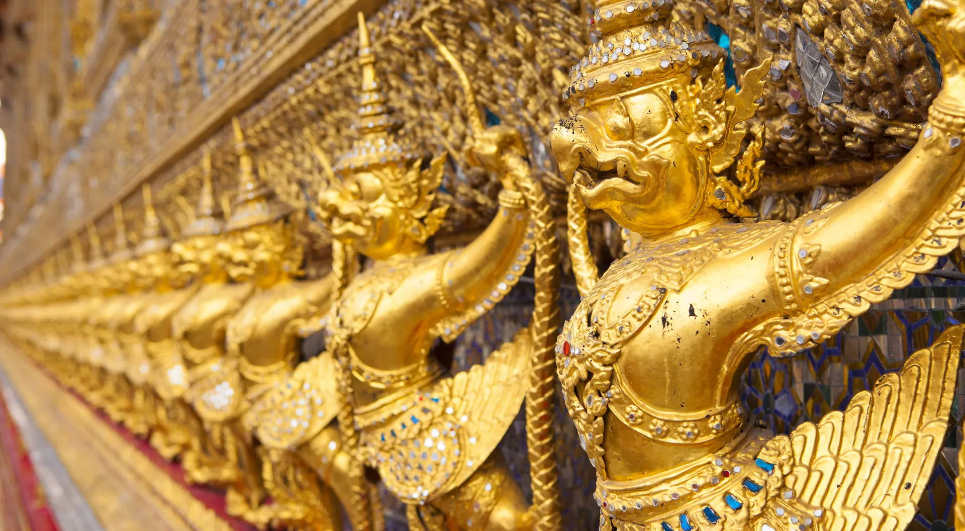 The Ubosot (Ordination Hall) at Wat Phra Kaew temple, Grand Palace, Bangkok. It is decorated with a golden row of 112 Garudas (demigods).