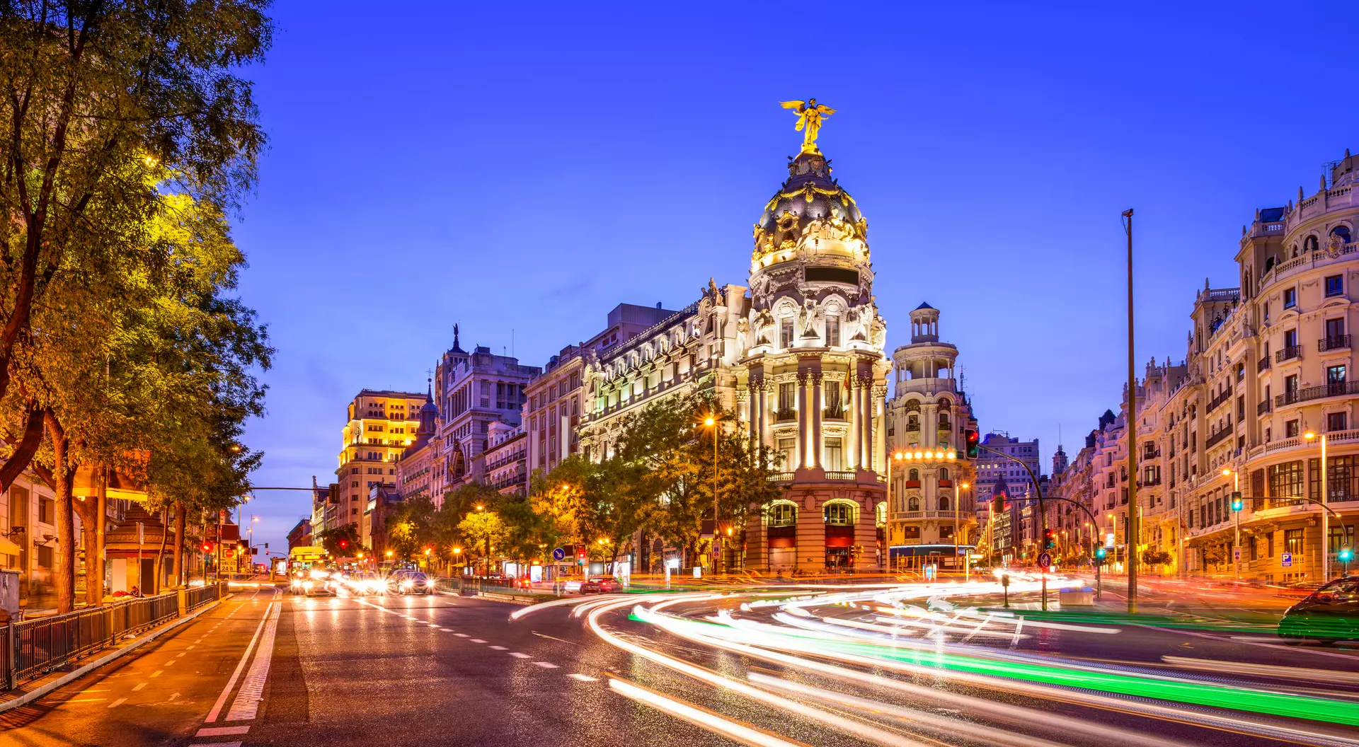 Rays of traffic lights on Gran via street, main shopping street in Madrid at night. Spain, Europe.
