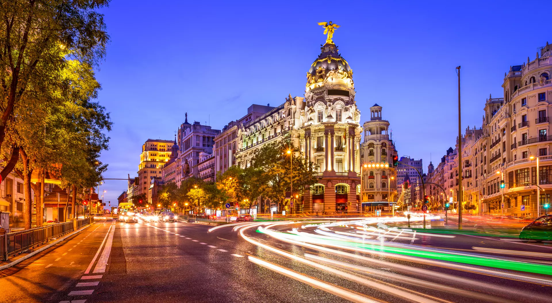 Rays of traffic lights on Gran via street, main shopping street in Madrid at night. Spain, Europe.
