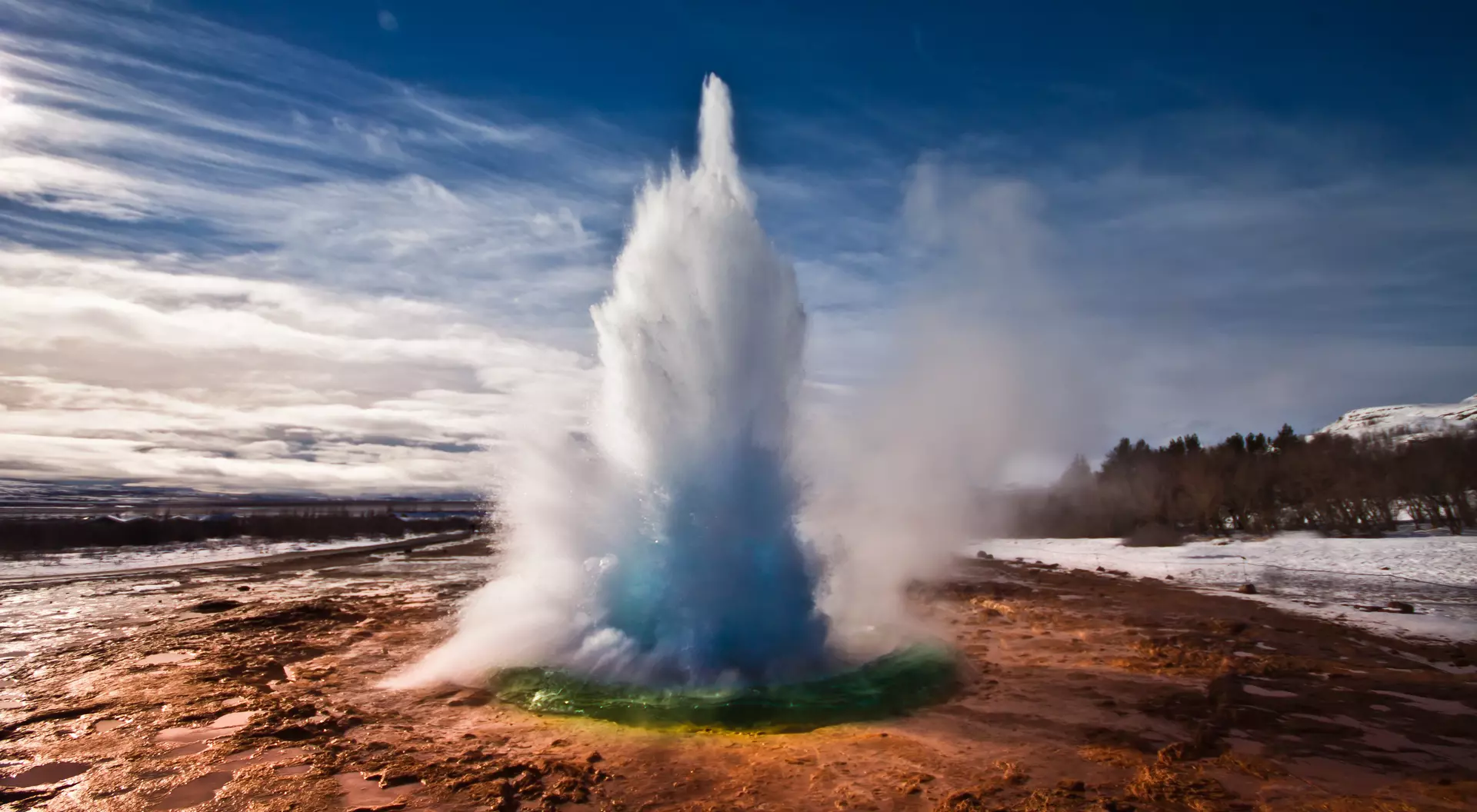 Erupting Strokkur Geyser on a sunny day in Iceland.
