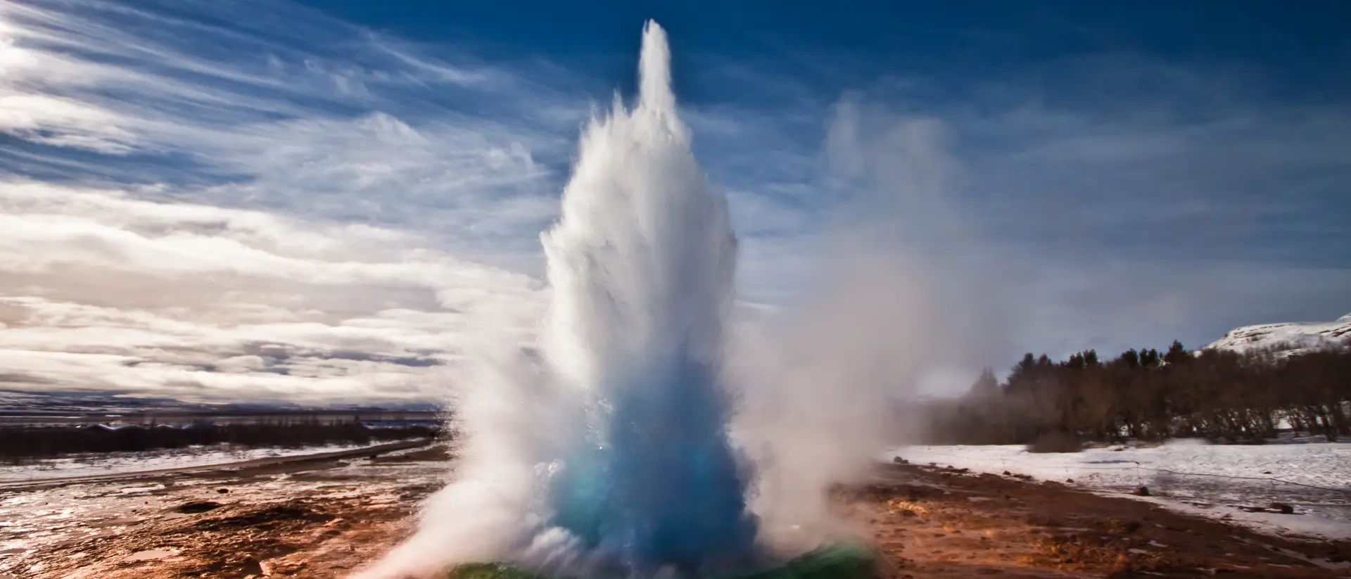 Erupting Strokkur Geyser on a sunny day in Iceland.