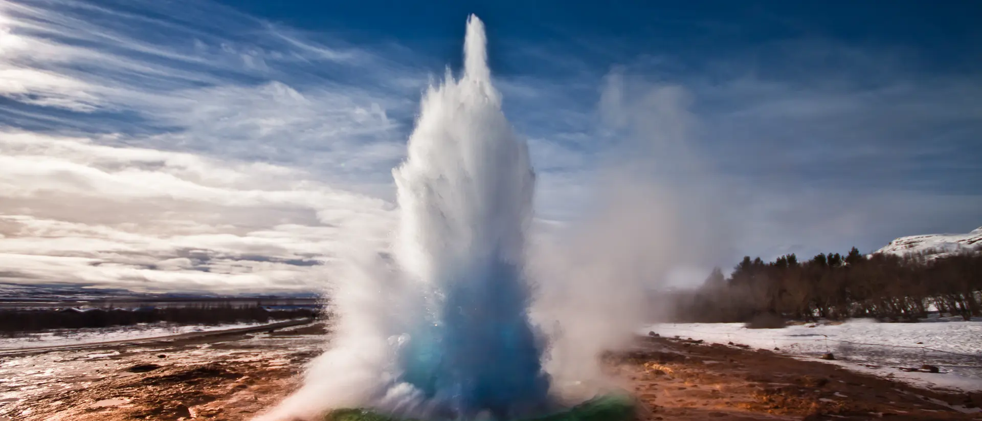 Erupting Strokkur Geyser on a sunny day in Iceland.