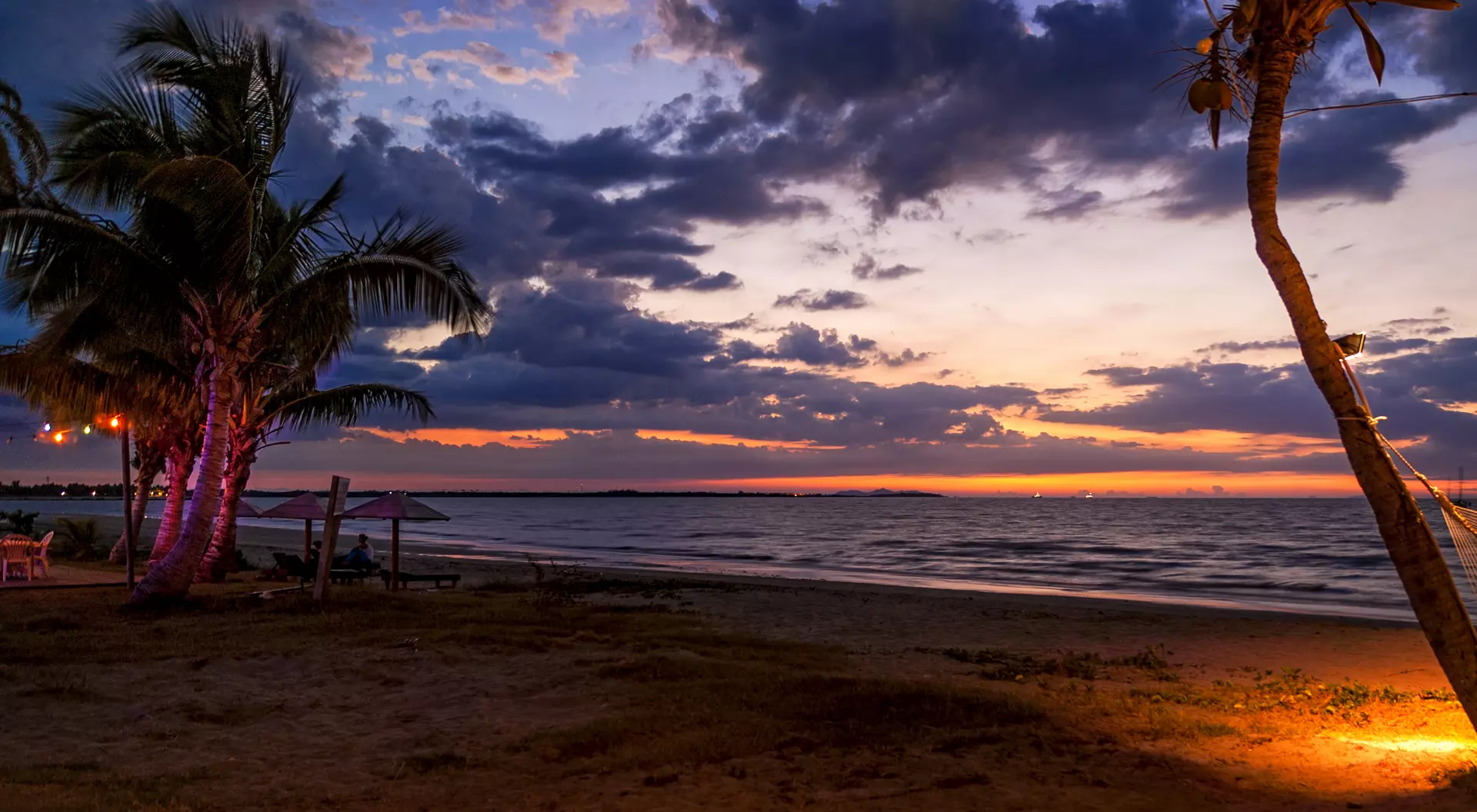 A beautiful beach setting comes to life as the sun goes down.
