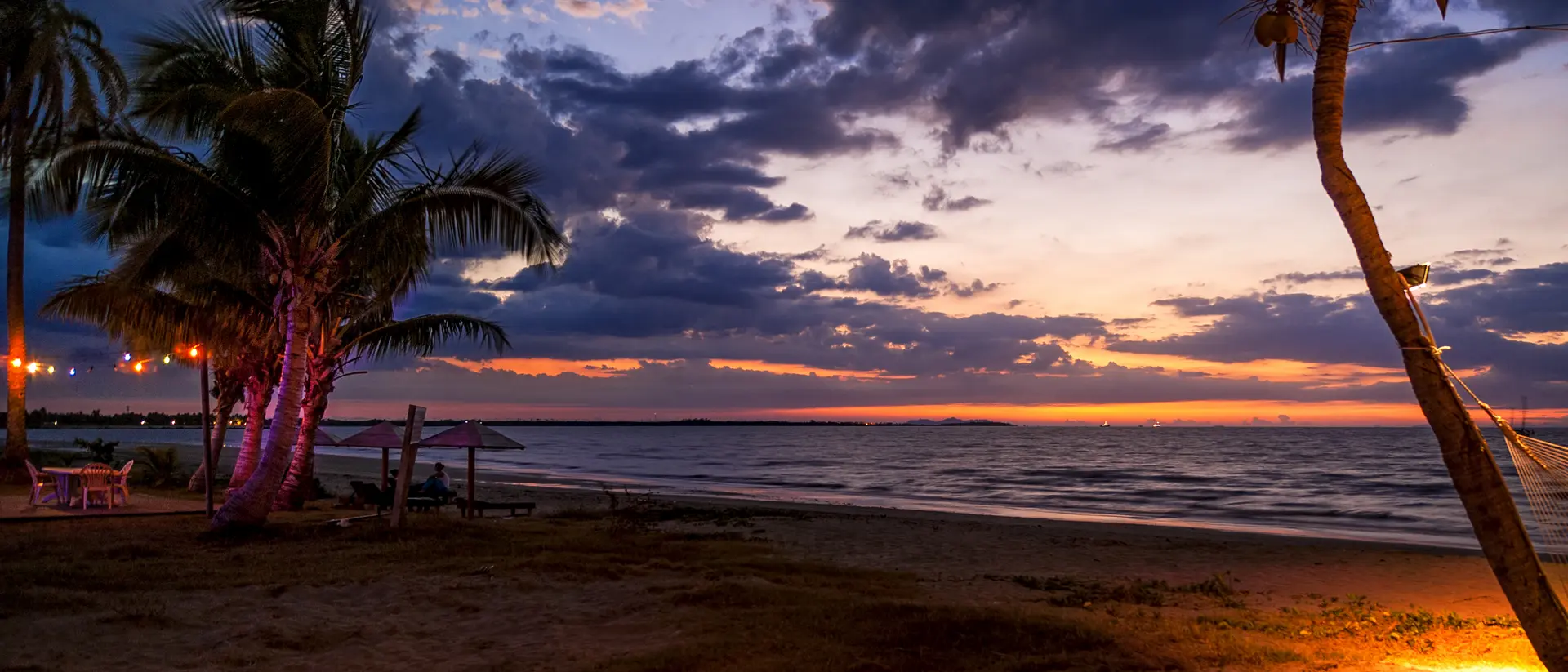 A beautiful beach setting comes to life as the sun goes down.