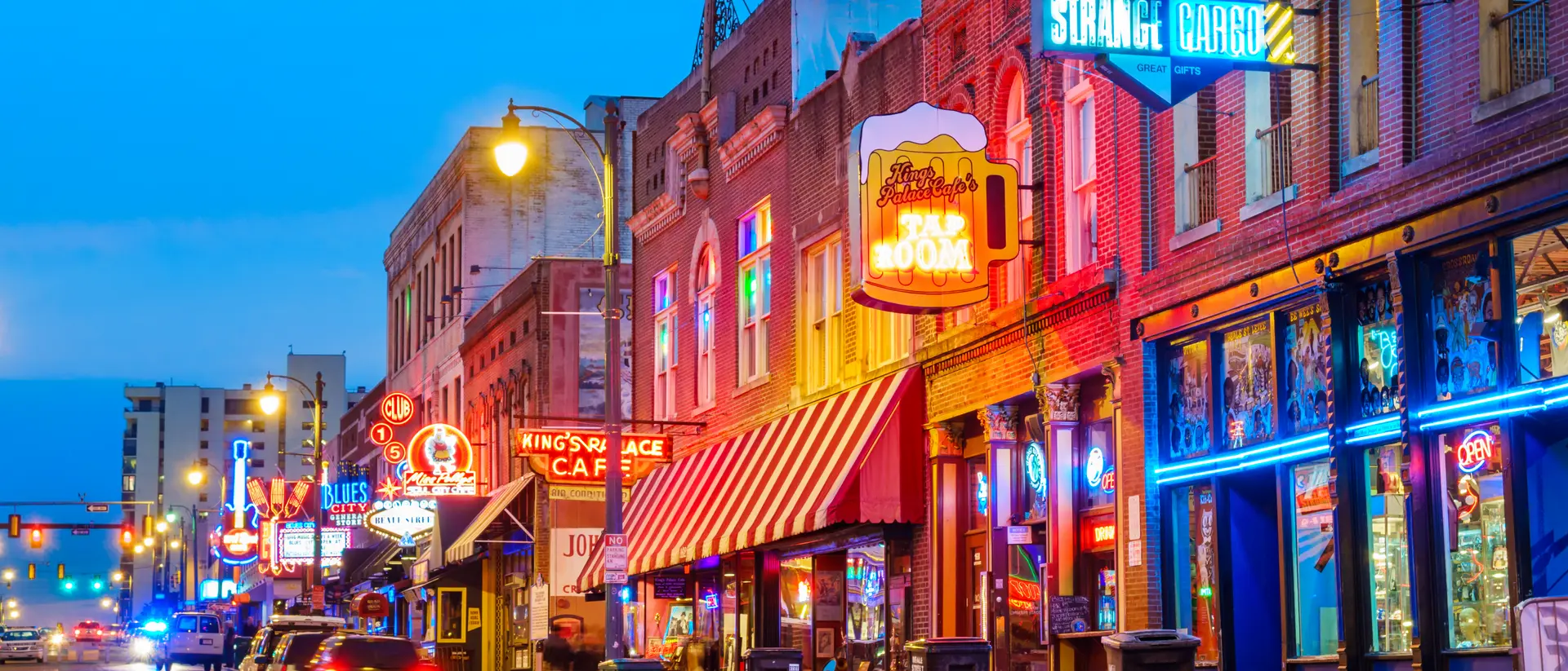 Photo of colorful cafe bars at the iconic Beale Street music and entertainment district of downtown Memphis, Tennessee, USA, illuminated at night.