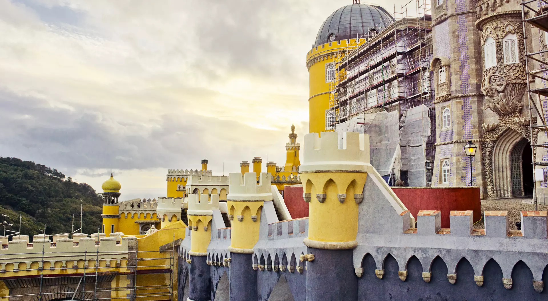 The colorful walls and towers of the Palácio Nacional da Pena in the historical Portuguese town of Sintra on a cloudy autumn day.