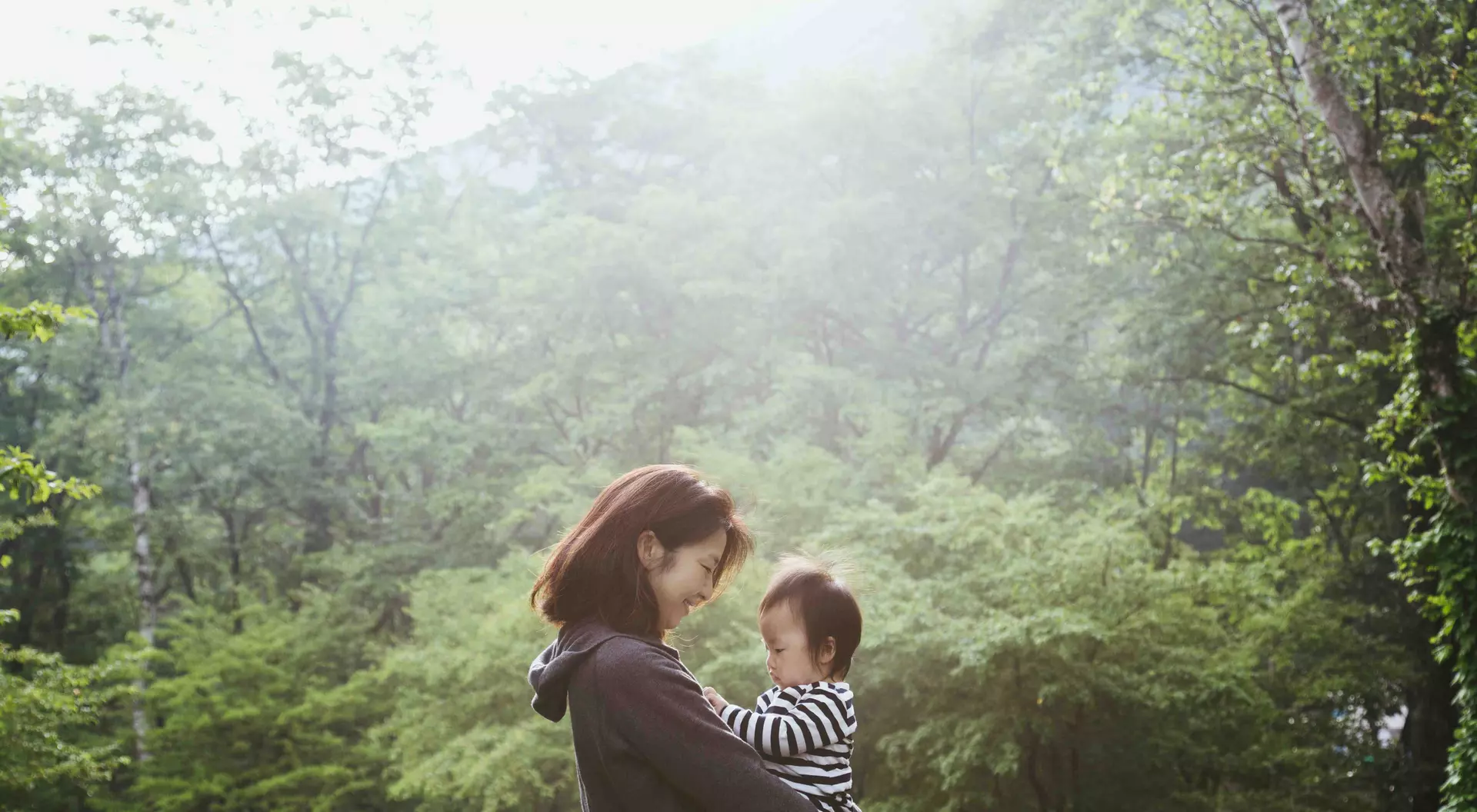 Mother carrying her baby girl in the mountain.
